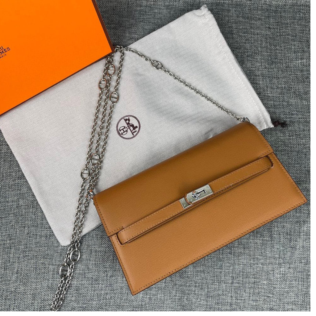 Hermès Kelly crossbody bag in brown leather with silver buckle.