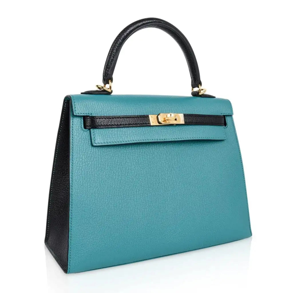 Close-up of Hermès Kelly 25 handbag in blue Epsom leather with gold clasp and padlock.