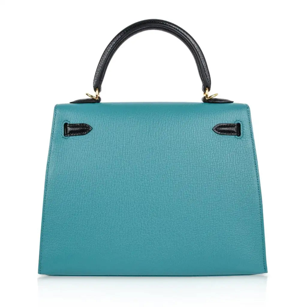 back view of Hermès Kelly 25 handbag in blue with gold hardware.